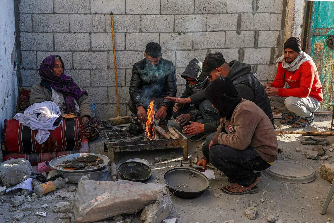 在加沙南部的拉法，当地人民在被炸毁的屋外准备食物。（法新社）