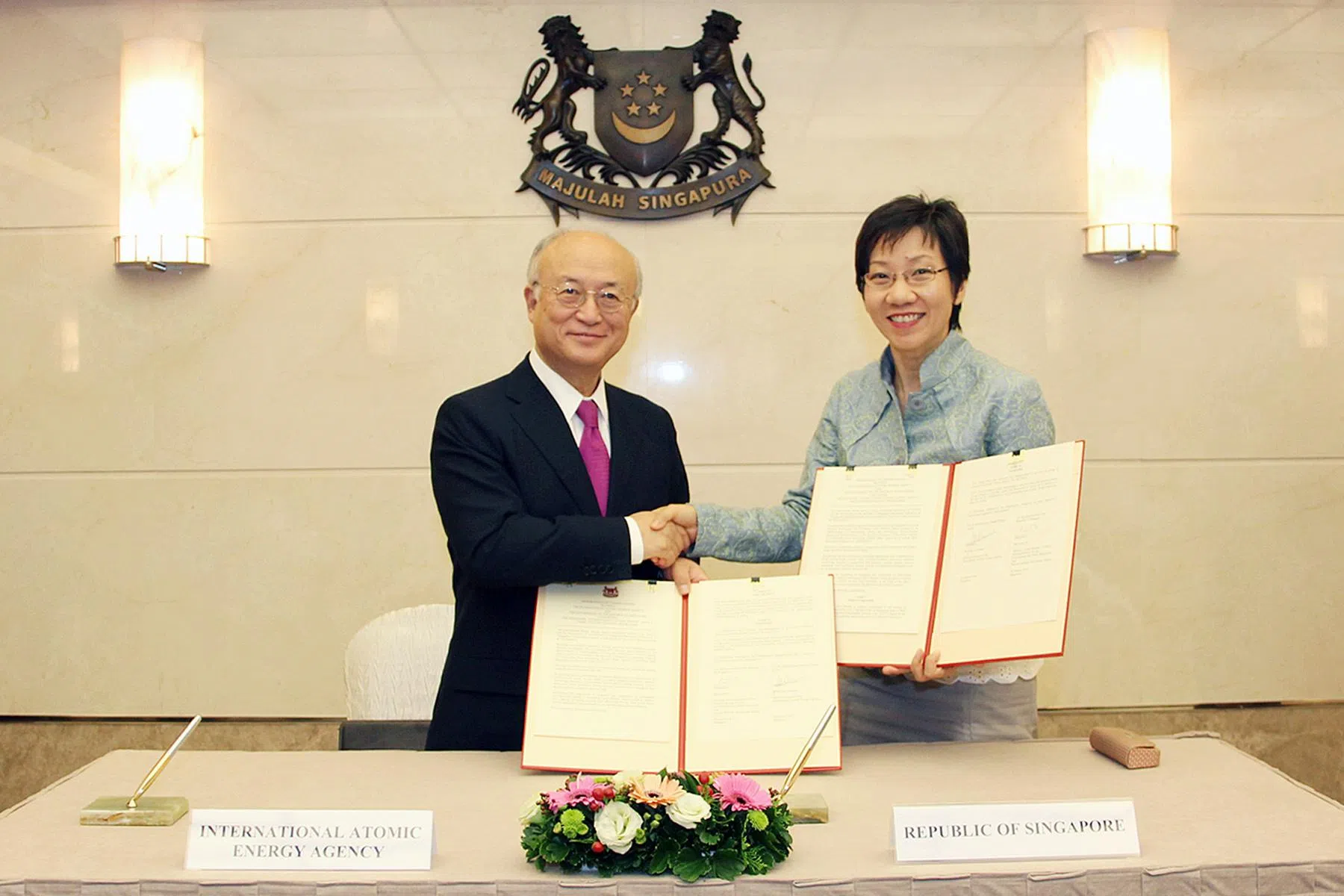 2015年，国际原子能机构时任总干事天野之弥（Yukiya Amano，左）访问我国，和永续发展与环境部长傅海燕签署谅解备忘录，更新第三国培训计划。（外交部提供）