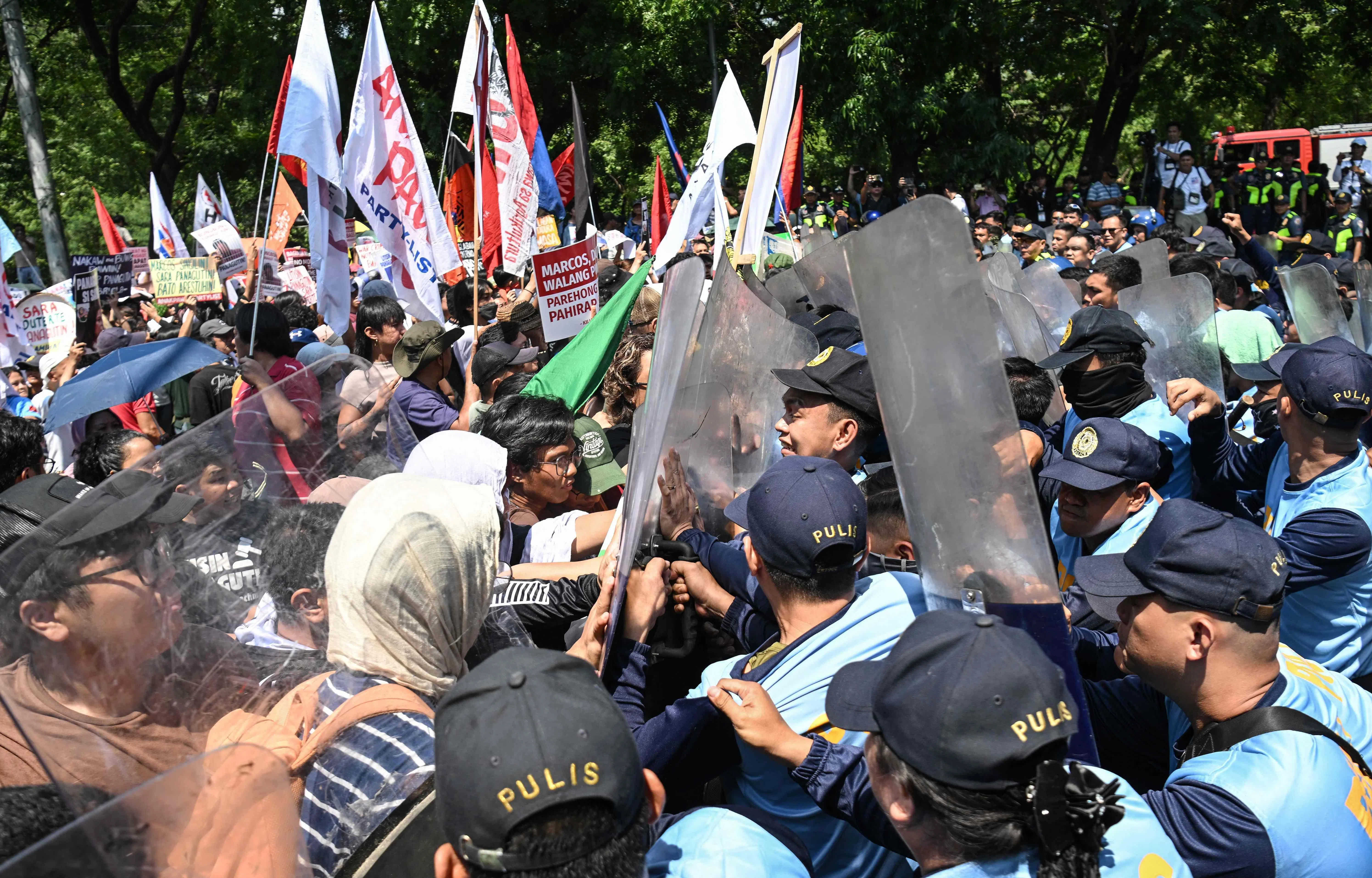 抗议者向参议院前进途中与警察发生推挤。马尼拉当局已在参议院大楼周围部署超过6000名警员，首都全境也进入全面警戒状态。（法新社）