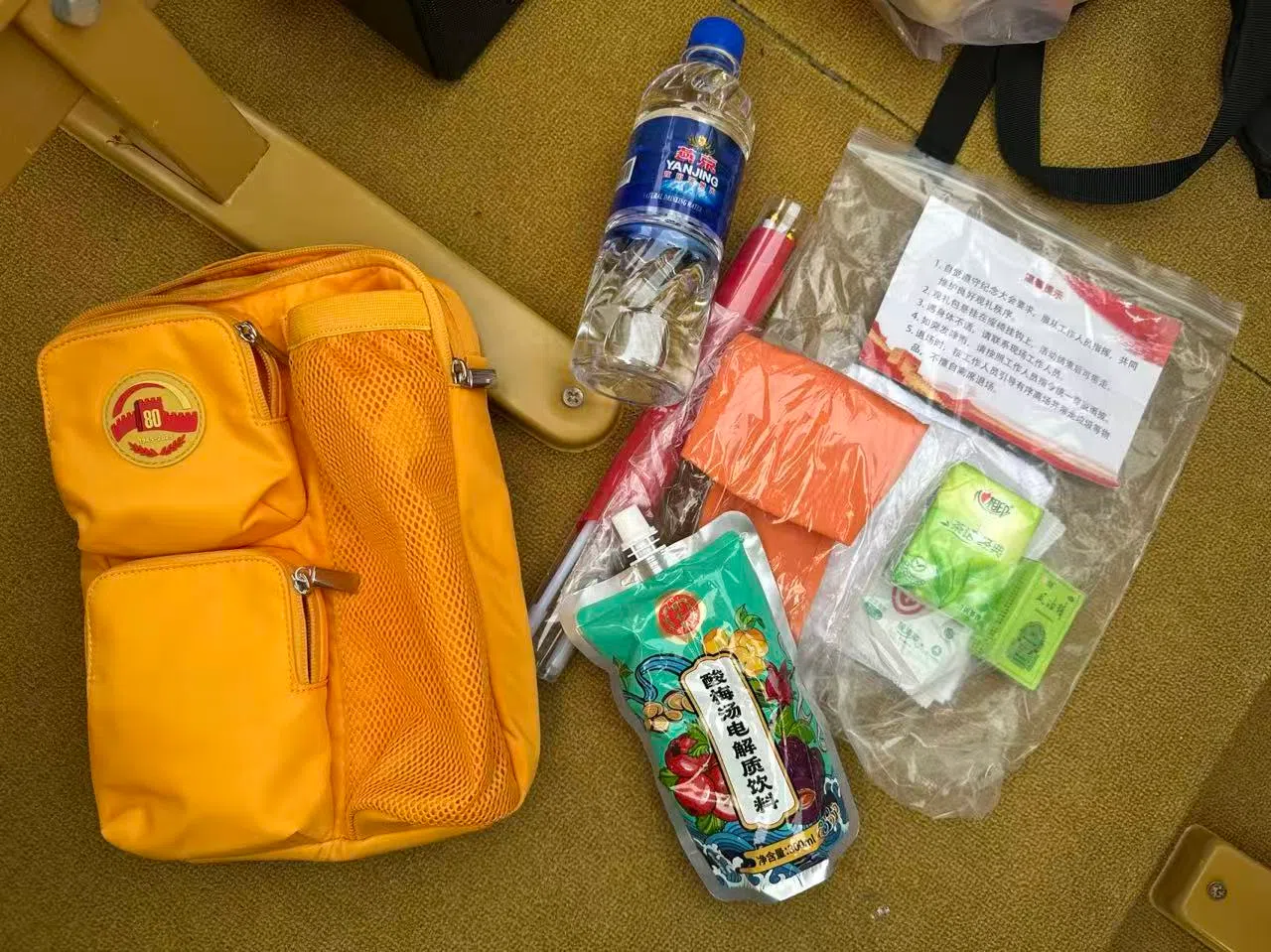 观礼包内有酸梅汤电解质饮料、纸巾、酒精湿纸、风油精、毛巾、帽子、矿泉水、中国国旗等。（周岳翔摄）