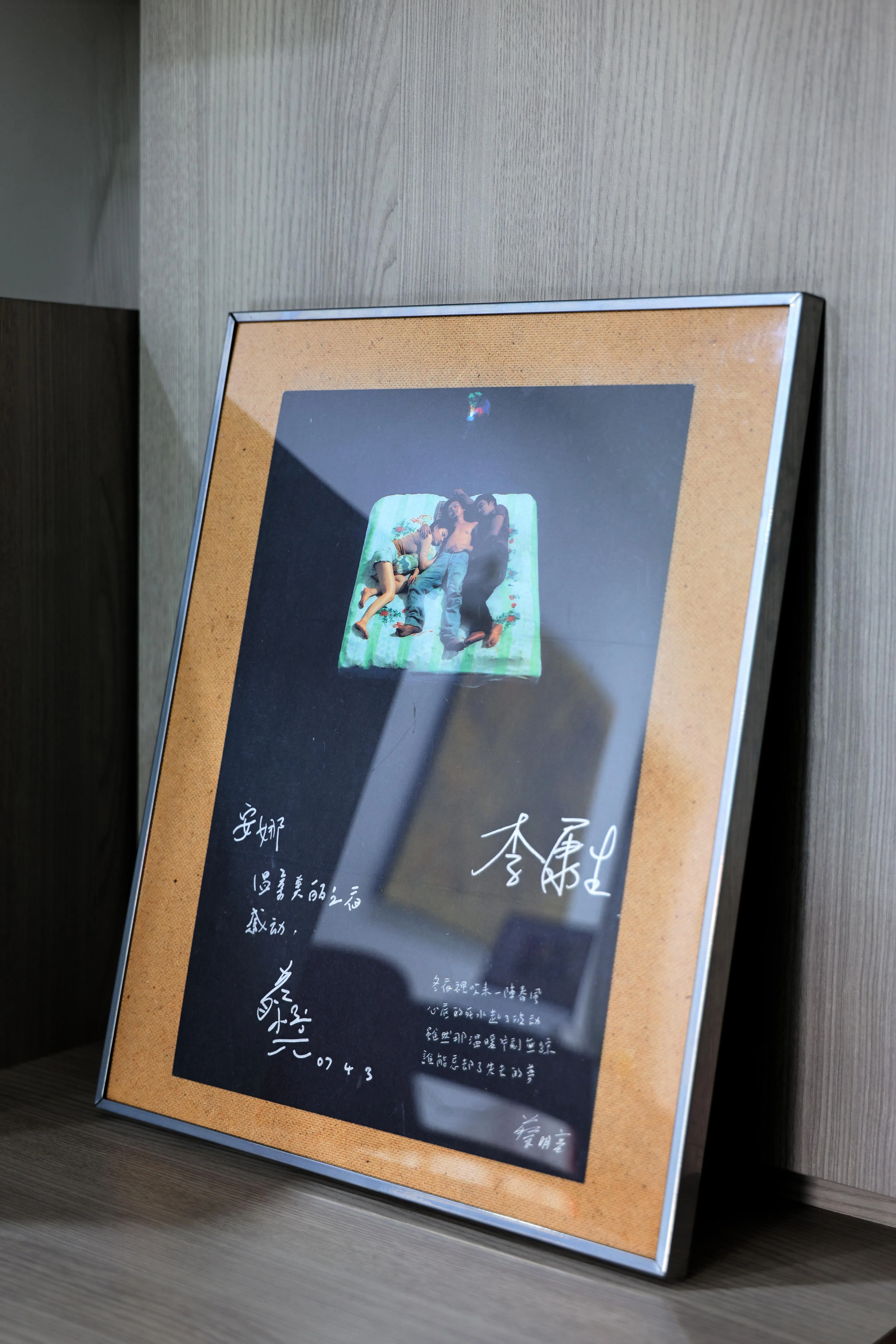 客厅酒柜旁摆放着导演蔡明亮题字、李康生签名的海报，林安娜装框收藏至今。（龙国雄摄）