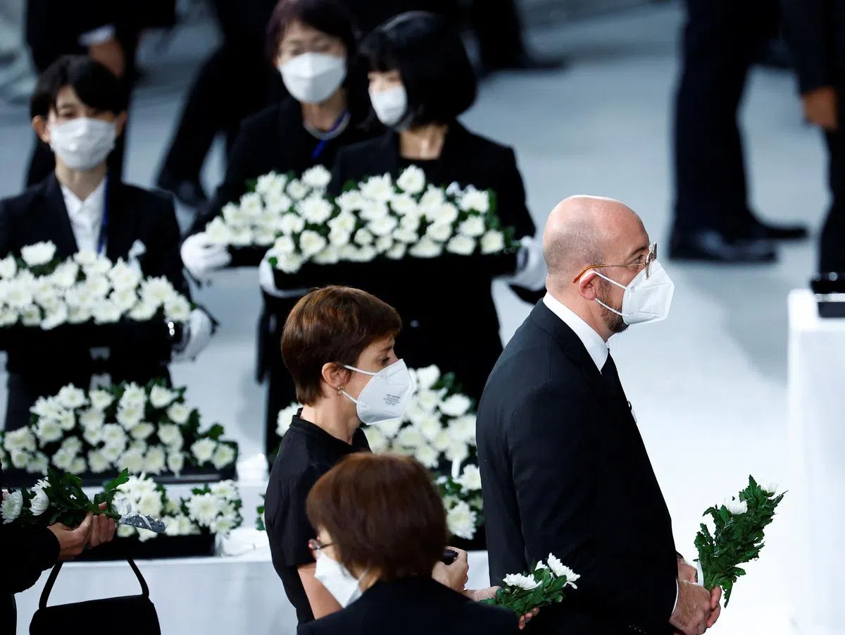 欧洲理事会主席米歇尔（右一）走向祭坛，向安倍晋三献花。（路透社） 