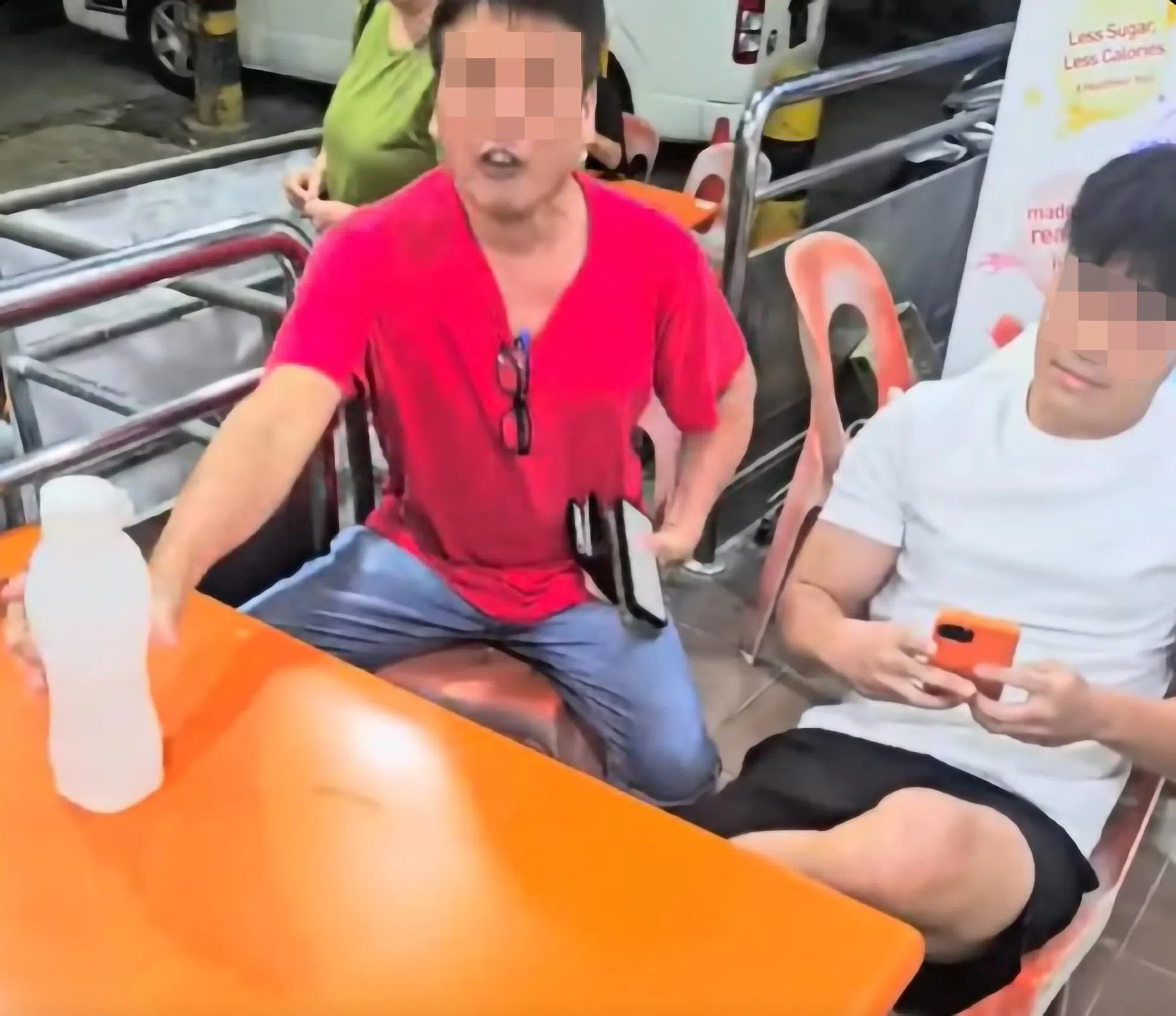 饮料摊主在社媒发布的视频显示，父亲（左）与镜头背后的摊主激烈争吵，情绪激动；儿子在一旁准备好手机，说就等摊主动手拍下视频为证。站在父亲背后的是这家人的母亲，过程中也上前表达不满。（受访摊主提供、视频截图）
