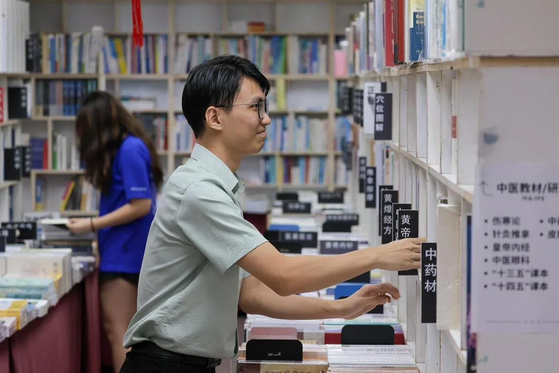 萧宇淮现在的目标是当好书店“引路人”，记住每本书的位置。（张俊杰摄）