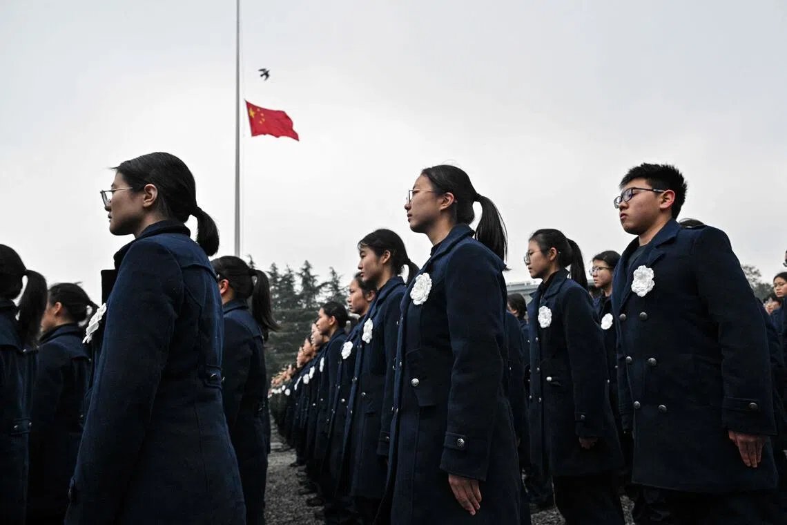 人们在南京大屠杀死难者公祭仪式现场默哀。（法新社）