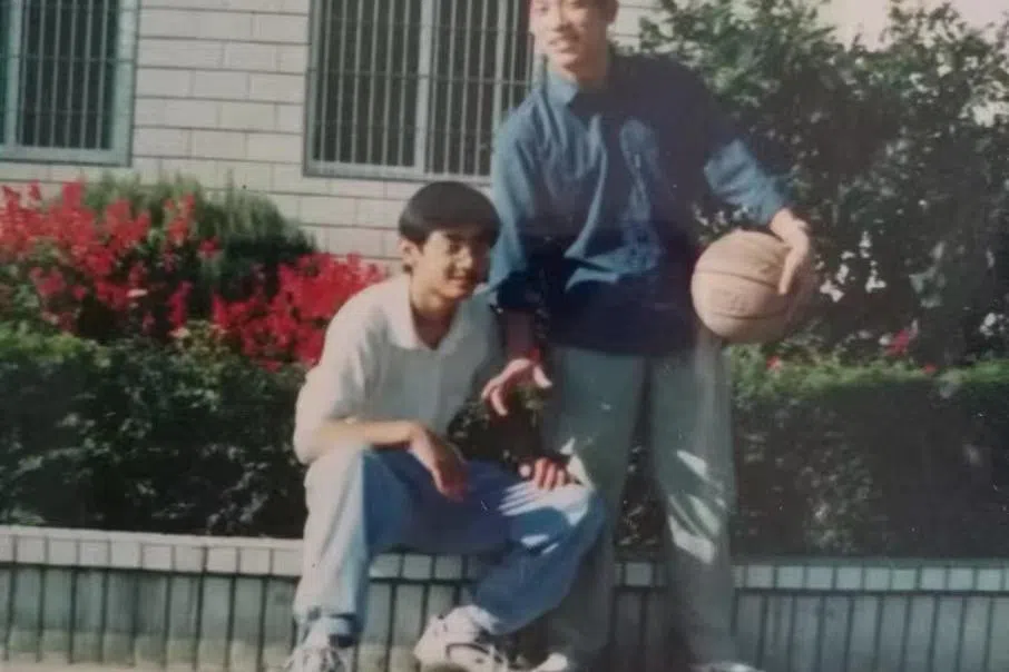 中学时期作为“金学盟主”的王晓磊（左）与同学一起，在校园推广金庸小说。（受访者提供）