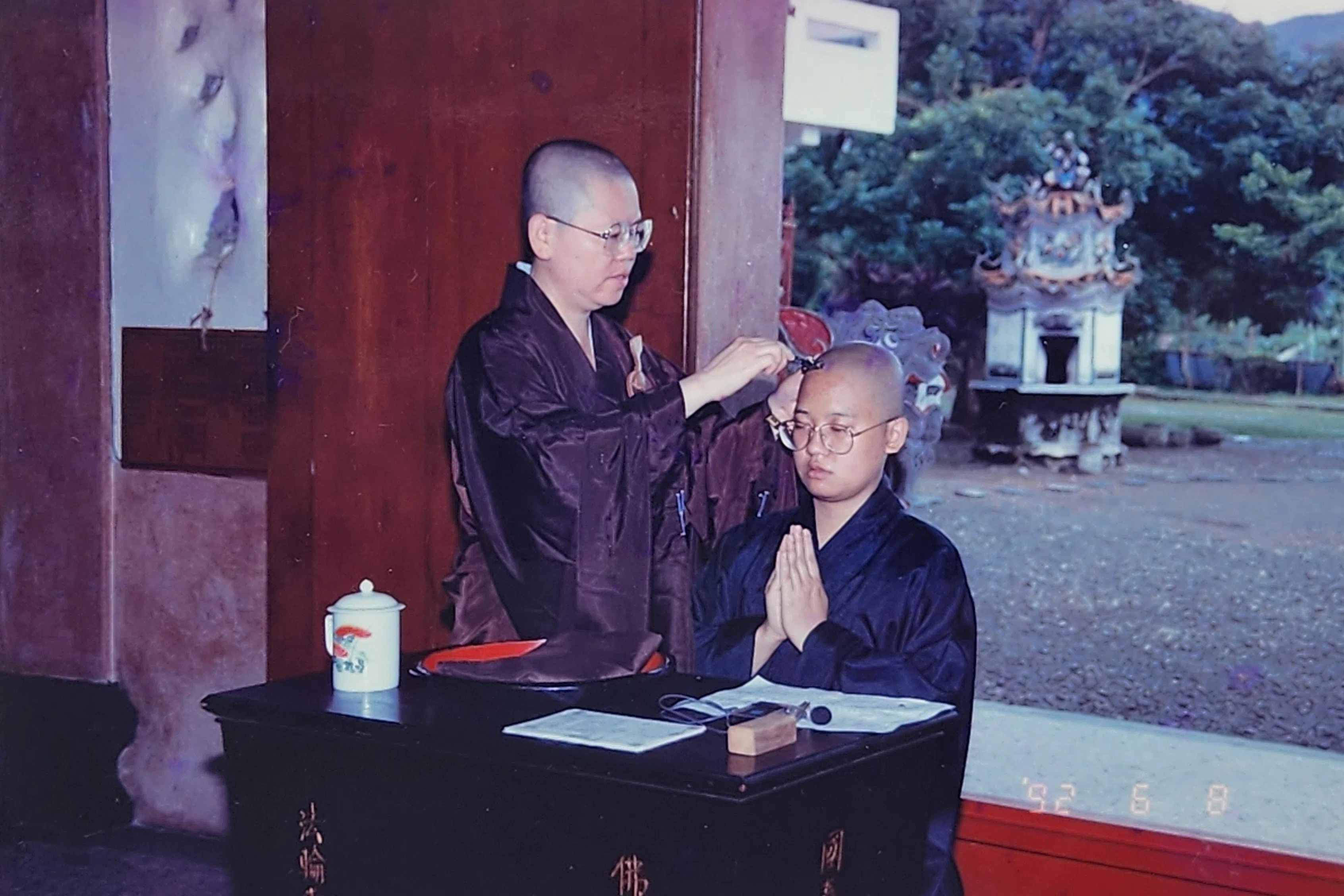 27岁的朱文莲（右）于1992年在台湾香光寺由时任住持明迦法师主持剃度仪式。（受访者提供）