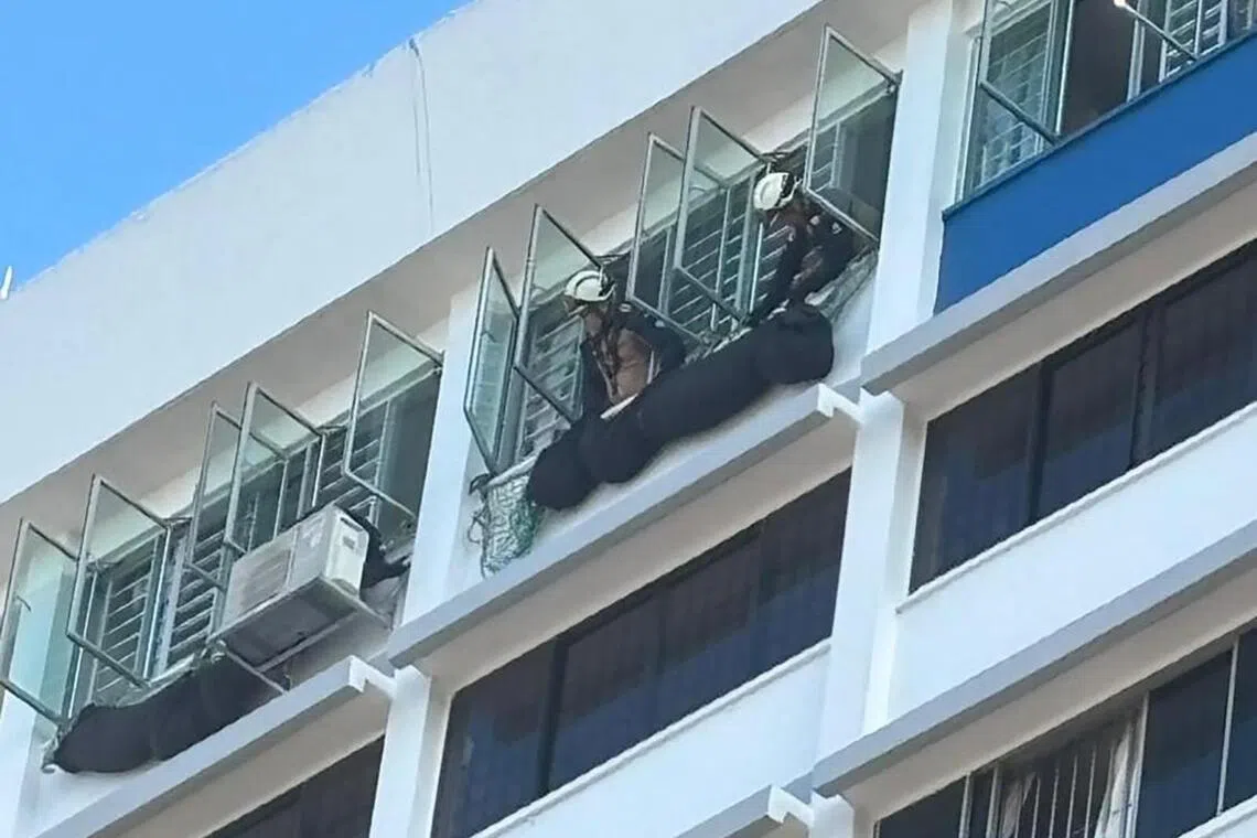 救援人员从14楼往事发单位的窗口查看情况。（受访者提供）