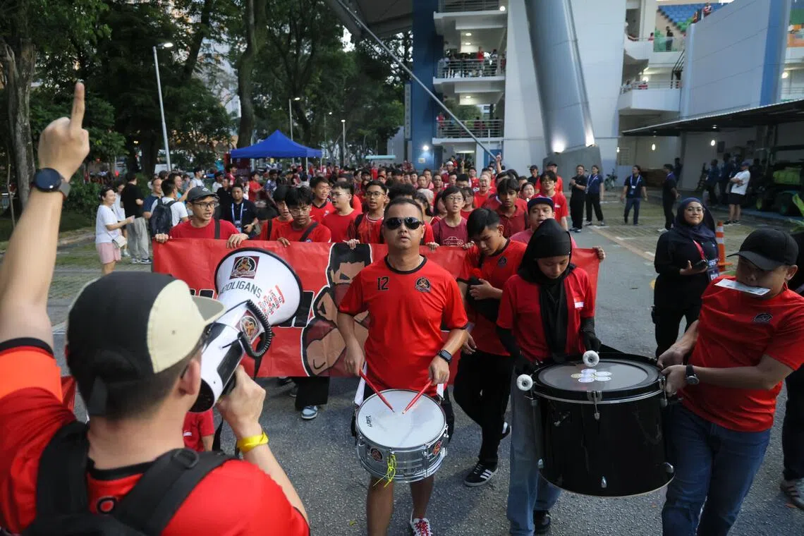雄狮球迷在赛前绕着惹兰勿刹体育场游行，并高唱助威歌曲，为主队造势。（张俊杰摄）