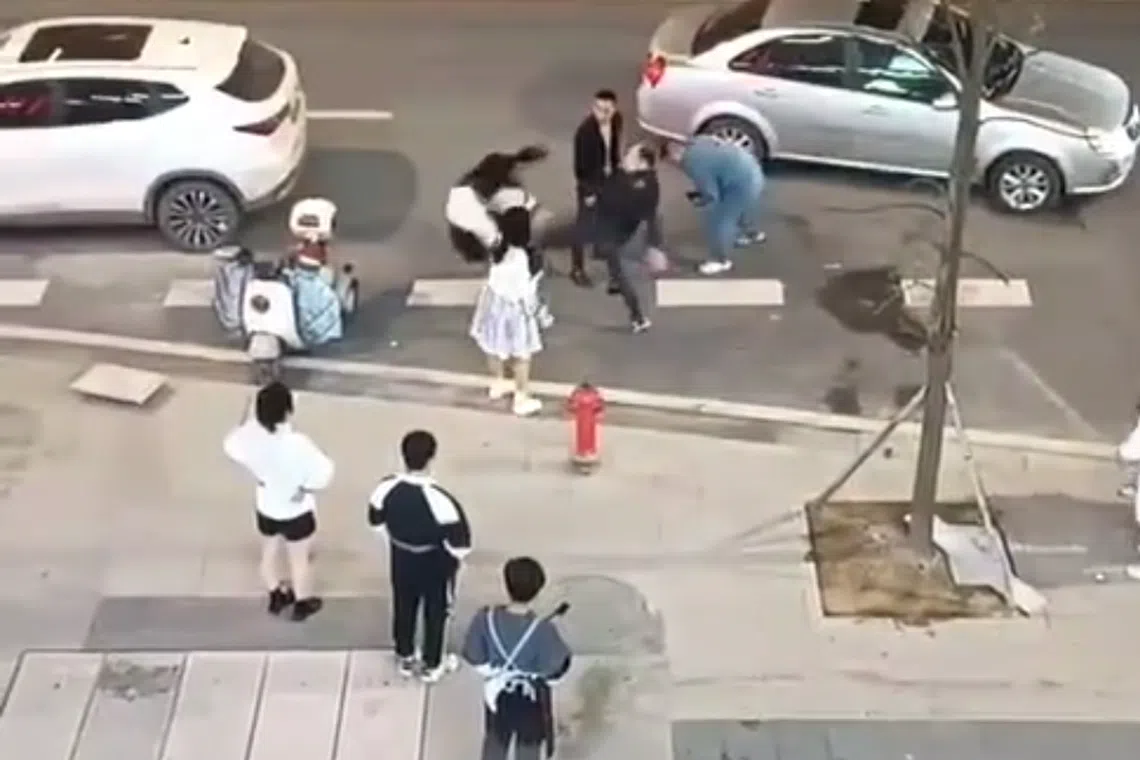 网传视频画面中，一名黑衣男子将一名白衣女孩“踹飞”，女孩重重地砸在不远处的电动车上。（互联网）