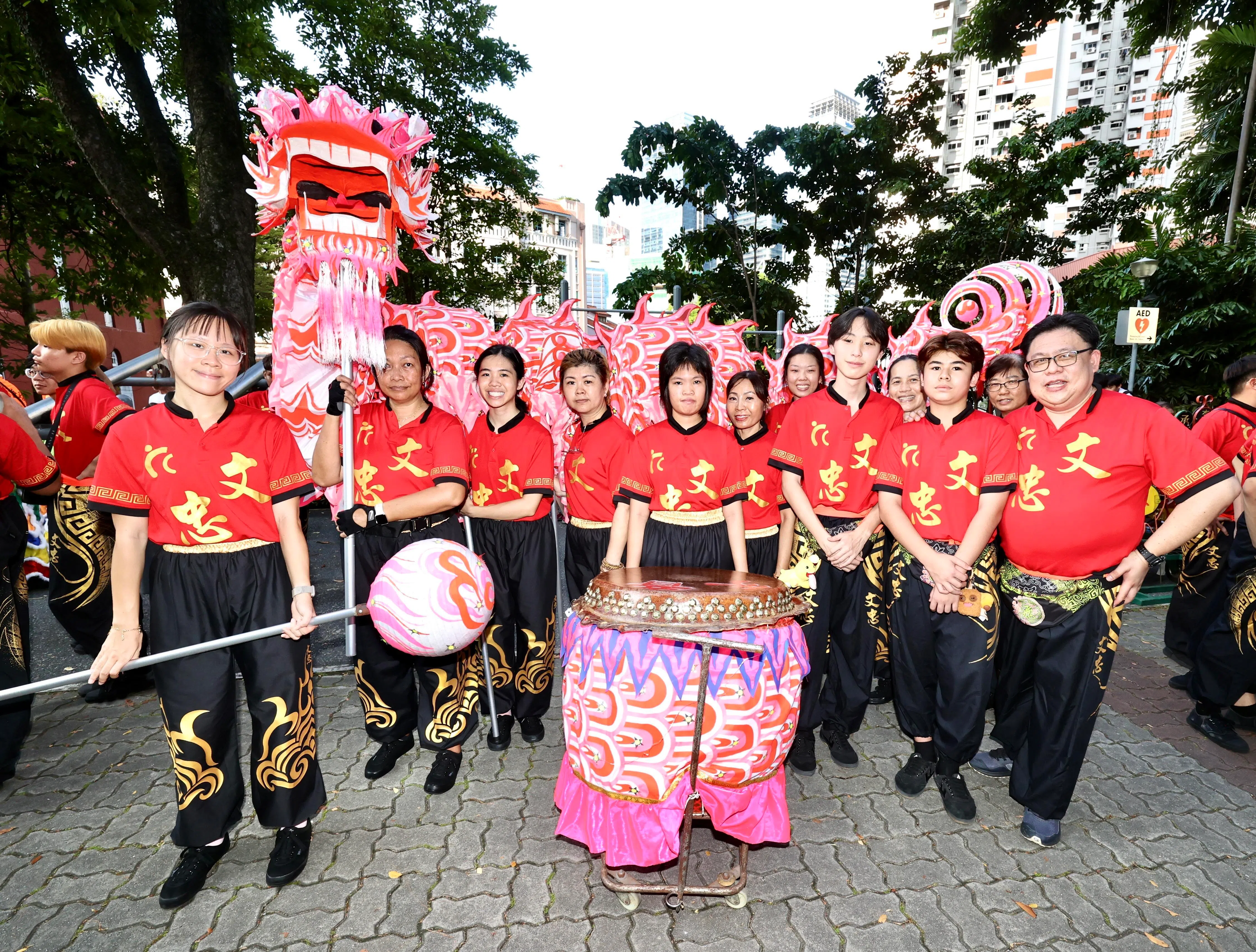 司徒宇恩（左一）与妹妹司徒宇容（左三）和母亲余春香（后排右二）是文忠居民委员会龙狮团的女子舞龙团成员。（周国威摄）
