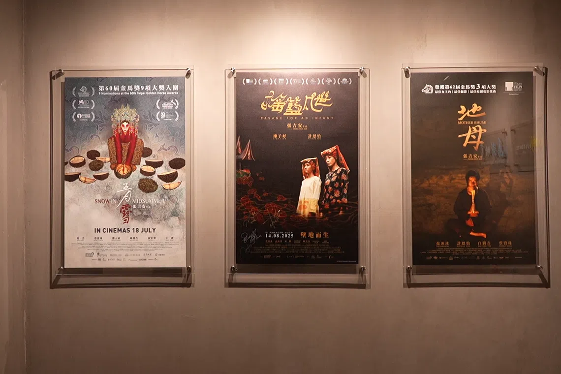 张吉安工作室墙上挂着三张他的电影作品海报。（视频截图）