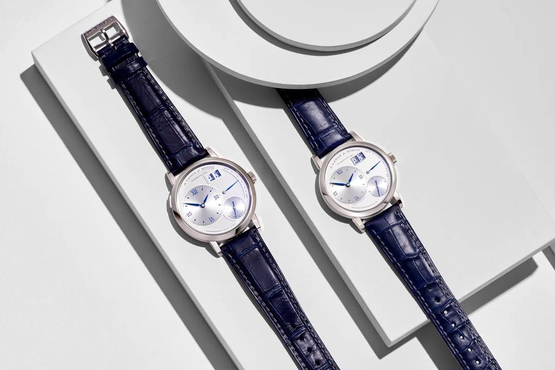 Lange 1以不对称表盘、偏心时分盘和大日期显示的独特设计，成为品牌标志性腕表。图为25周年版Grand Lange 1（左）和Little Lange 1。