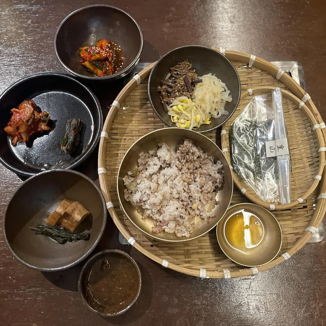 餐前小菜有大麦米饭、调味蔬菜和自家压榨的芝麻油。（黄靖晶摄）