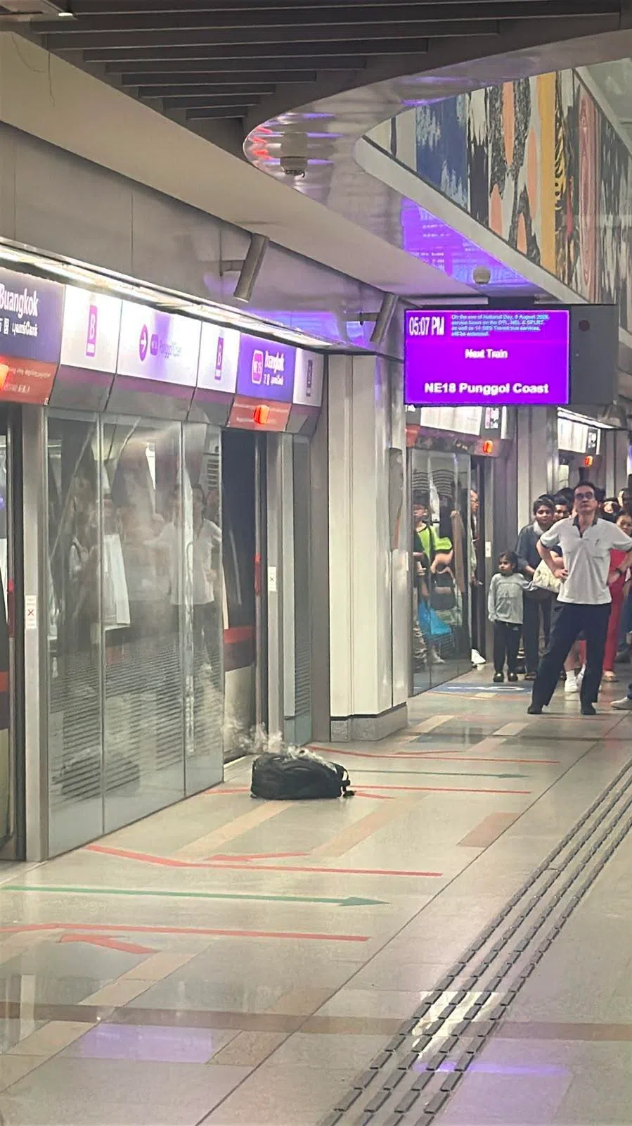 月台上一个背包持续冒出白烟，虽未见明火，但仍引起不少乘客警觉，纷纷后退躲避。（读者提供）