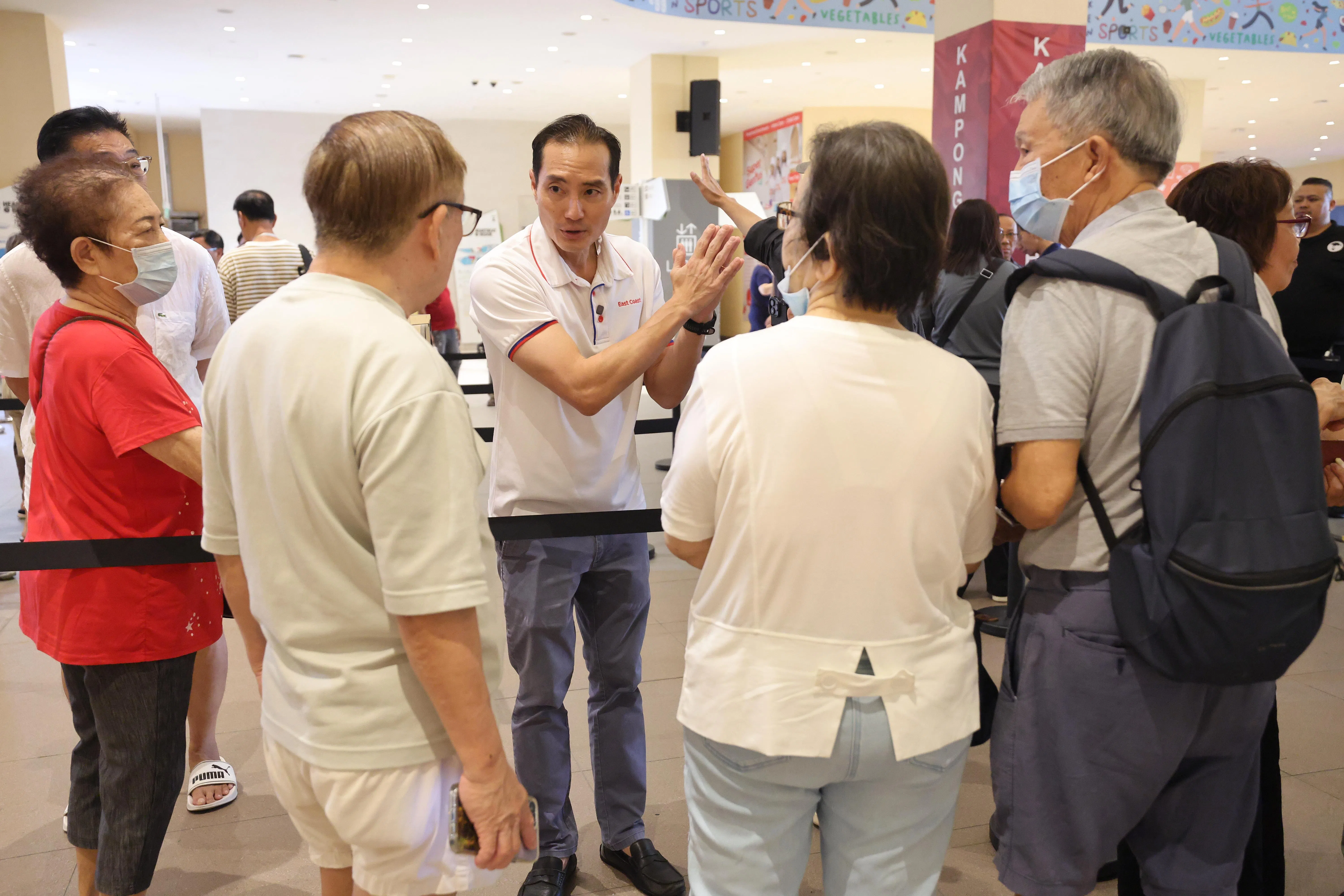 数码发展及新闻部兼保健卫生部高级政务部长陈杰豪（中）一早也到现场和公众交流，了解筛查情况。（唐家鸿摄）