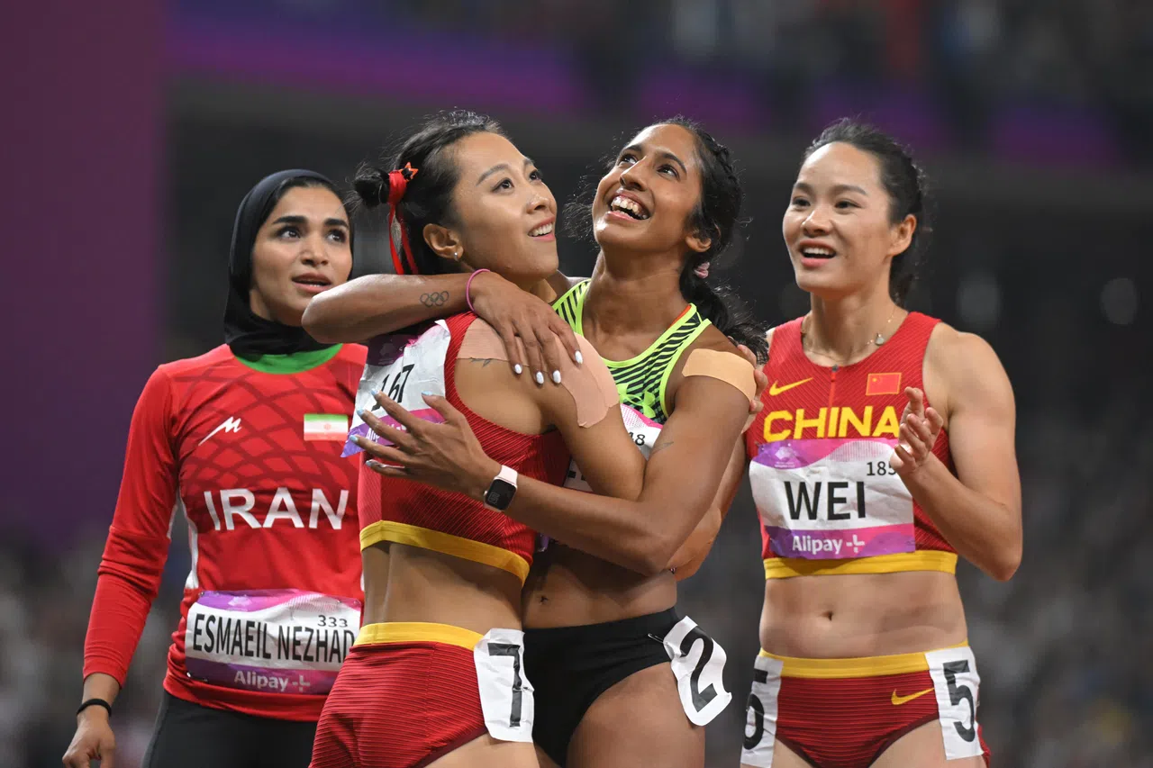 女飞人珊蒂（右二）在200米项目中夺冠，为我国赢得49年来首枚亚运会田径金牌。（海峡时报）