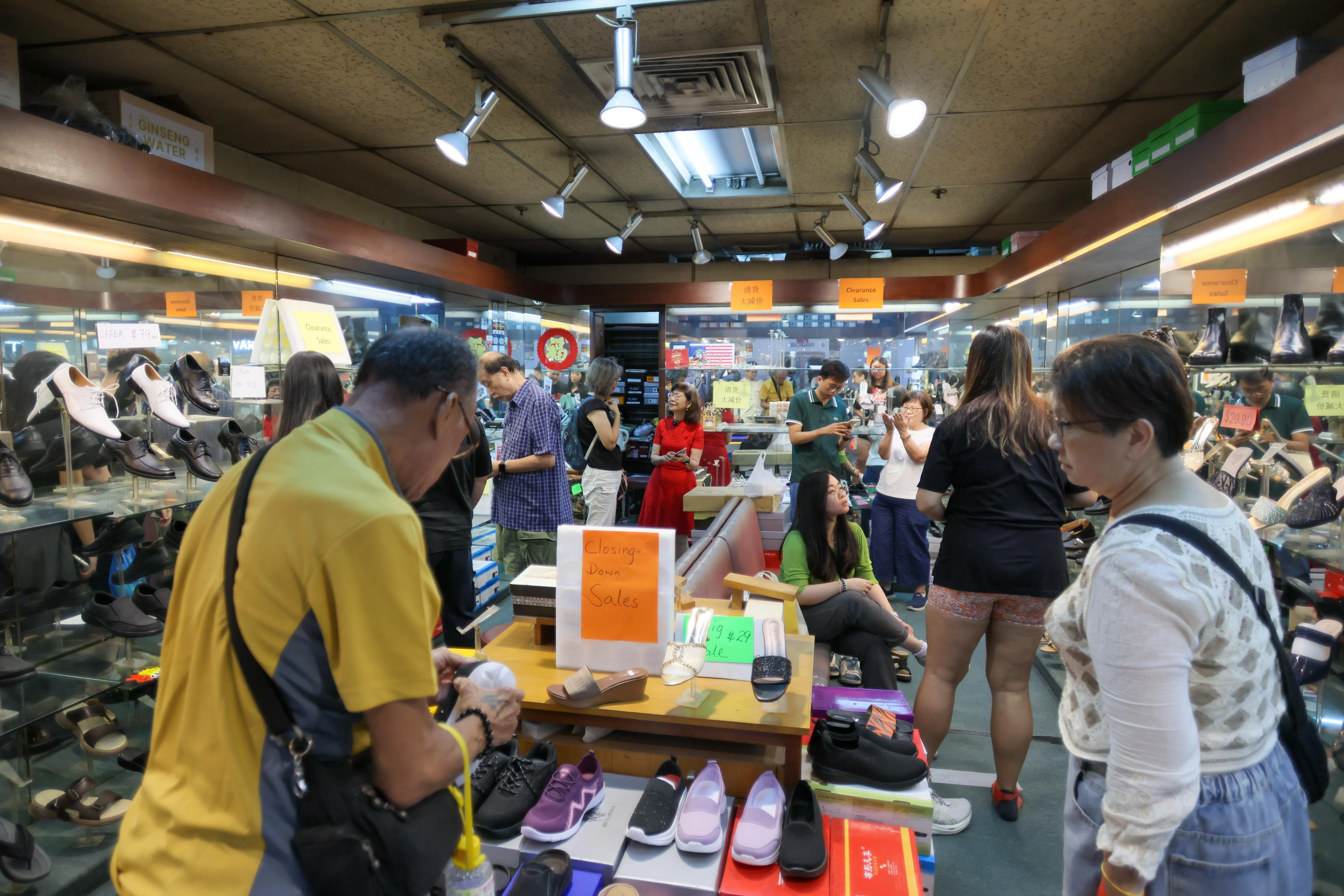 老顾客纷纷赶在最后几天上门，星期四下午的鞋店顾客络绎不绝。（张俊杰摄）