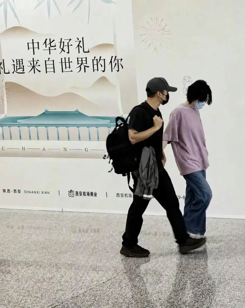 现身西安机场的谢霆锋与王菲均戴着口罩，但依然被路人认出。（互联网）