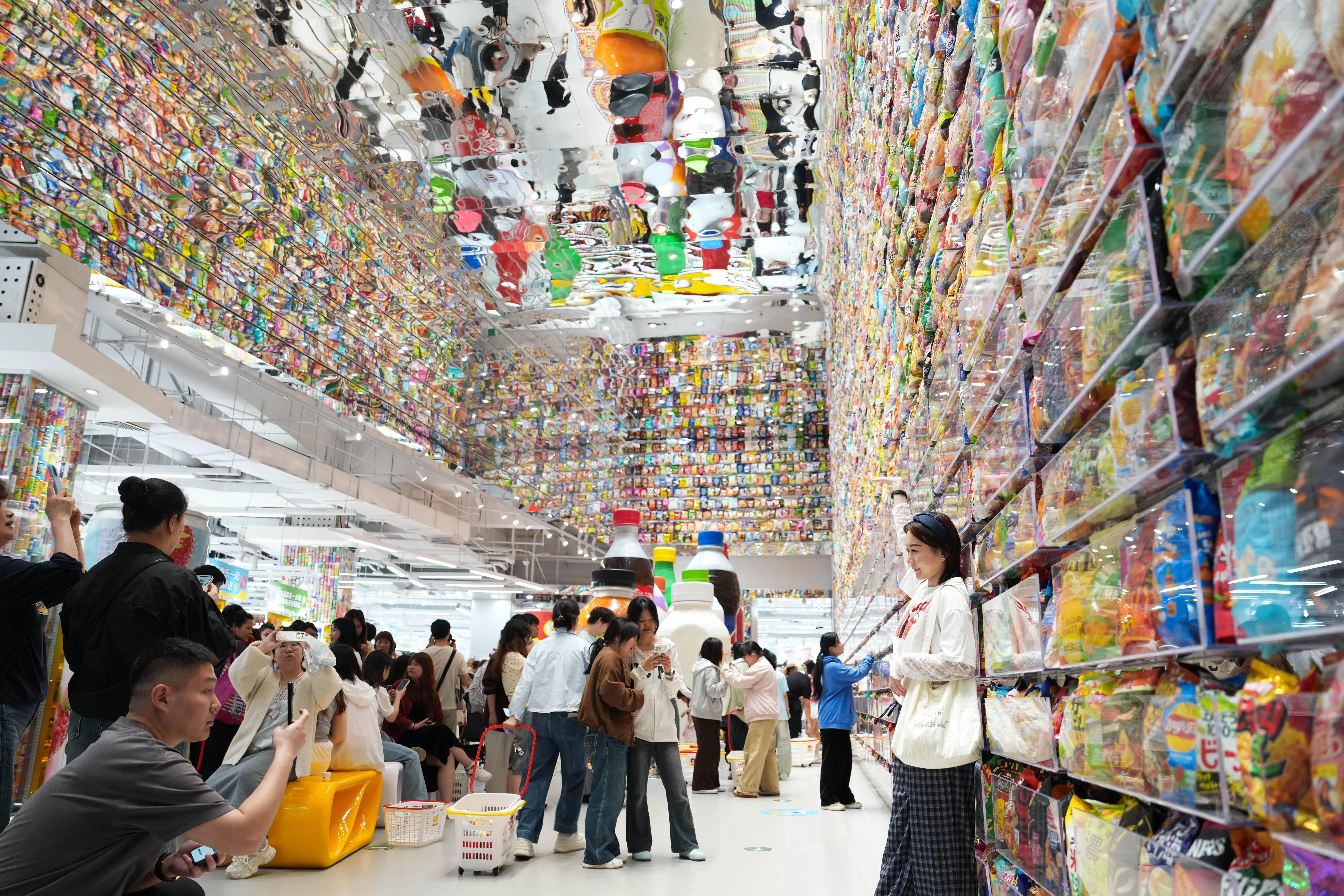 全球面积最大的零食店“零食王国”上个星期五（4月17日）在湖南长沙芙蓉广场正式开业，市民在店内拍照打卡。（新华社）
