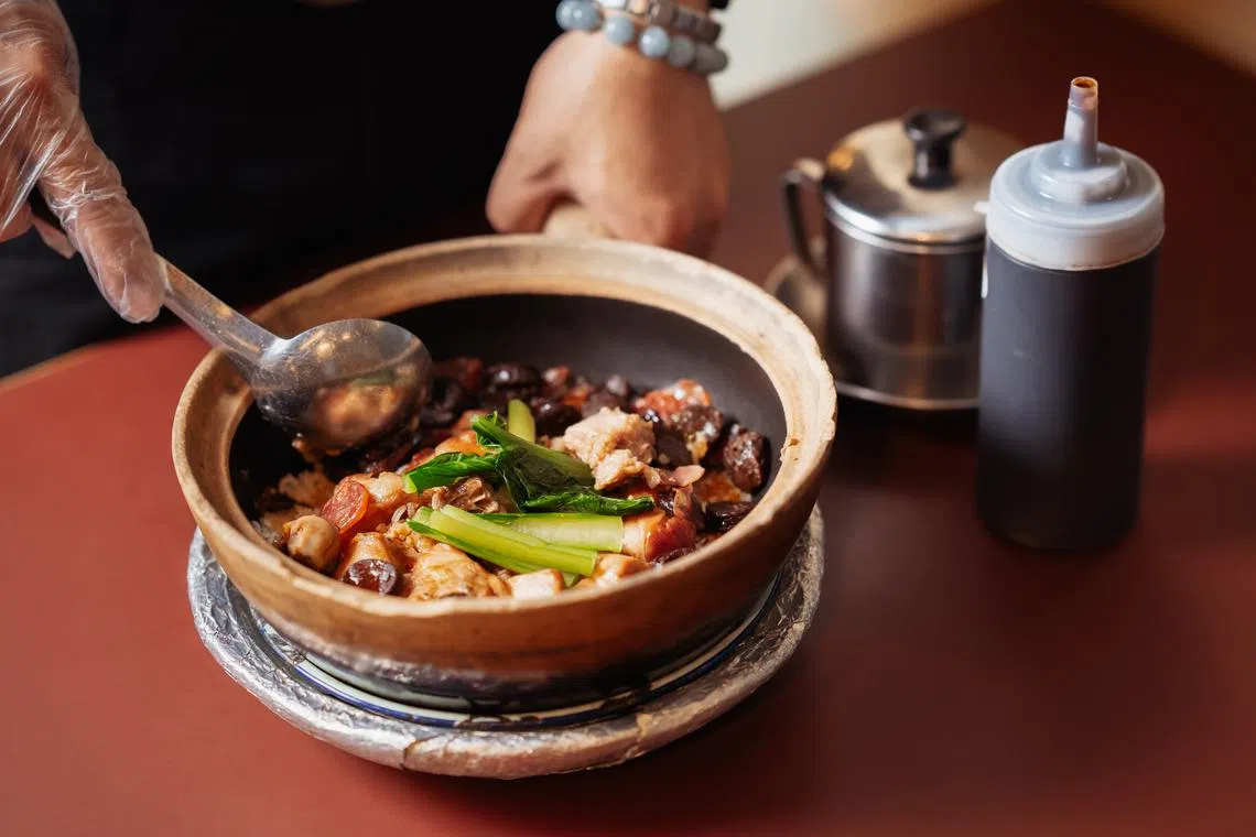 腊味滑鸡饭在翻搅时，咸鱼、腊肠和润肠的香气四溢。（餐馆提供）