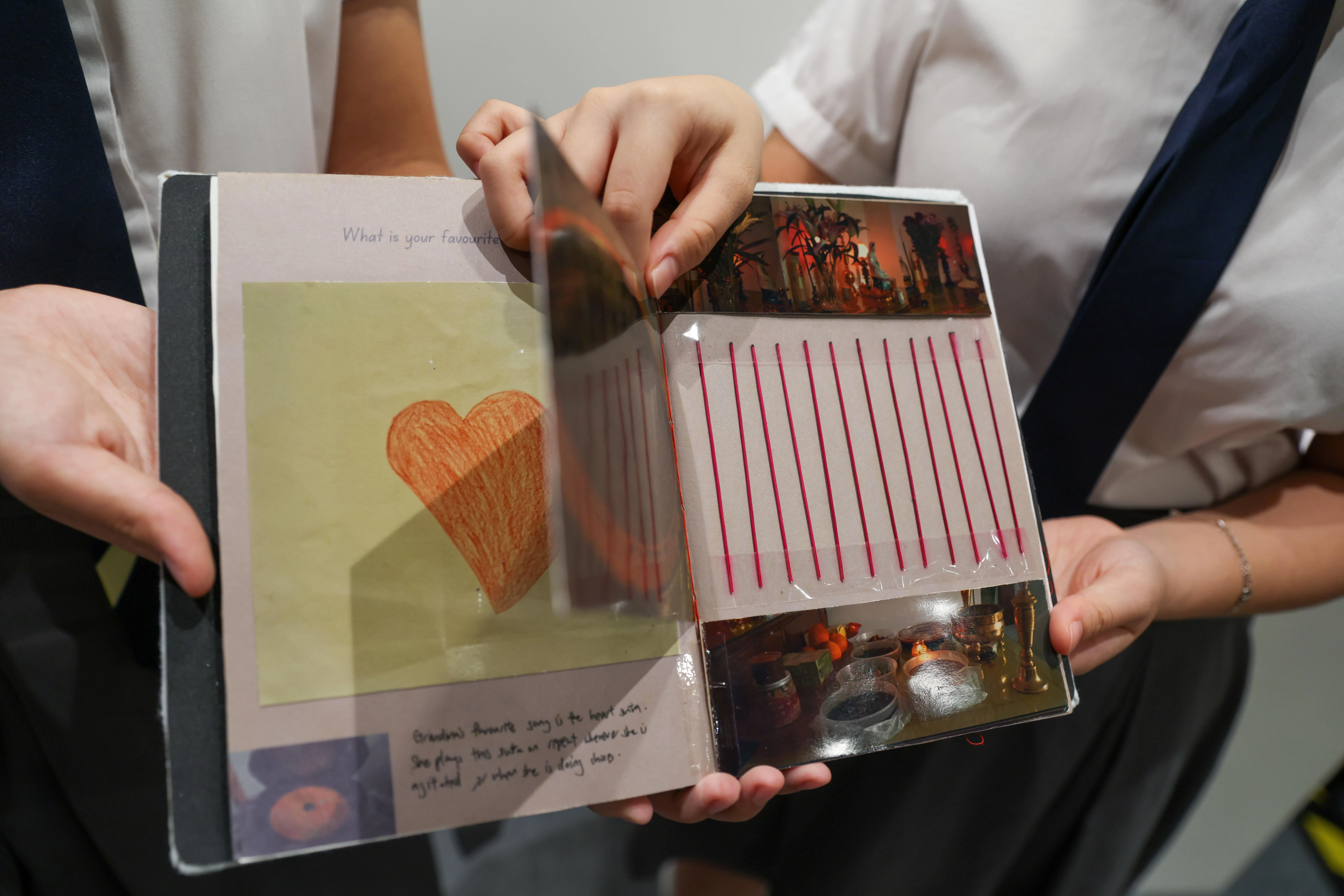 这件艺术作品以手工书形式呈现，里面包含了不同材质、质感的素材，如香炉照片背后贴着一排香炉中燃烧后留下的香脚。（白艳琳摄）