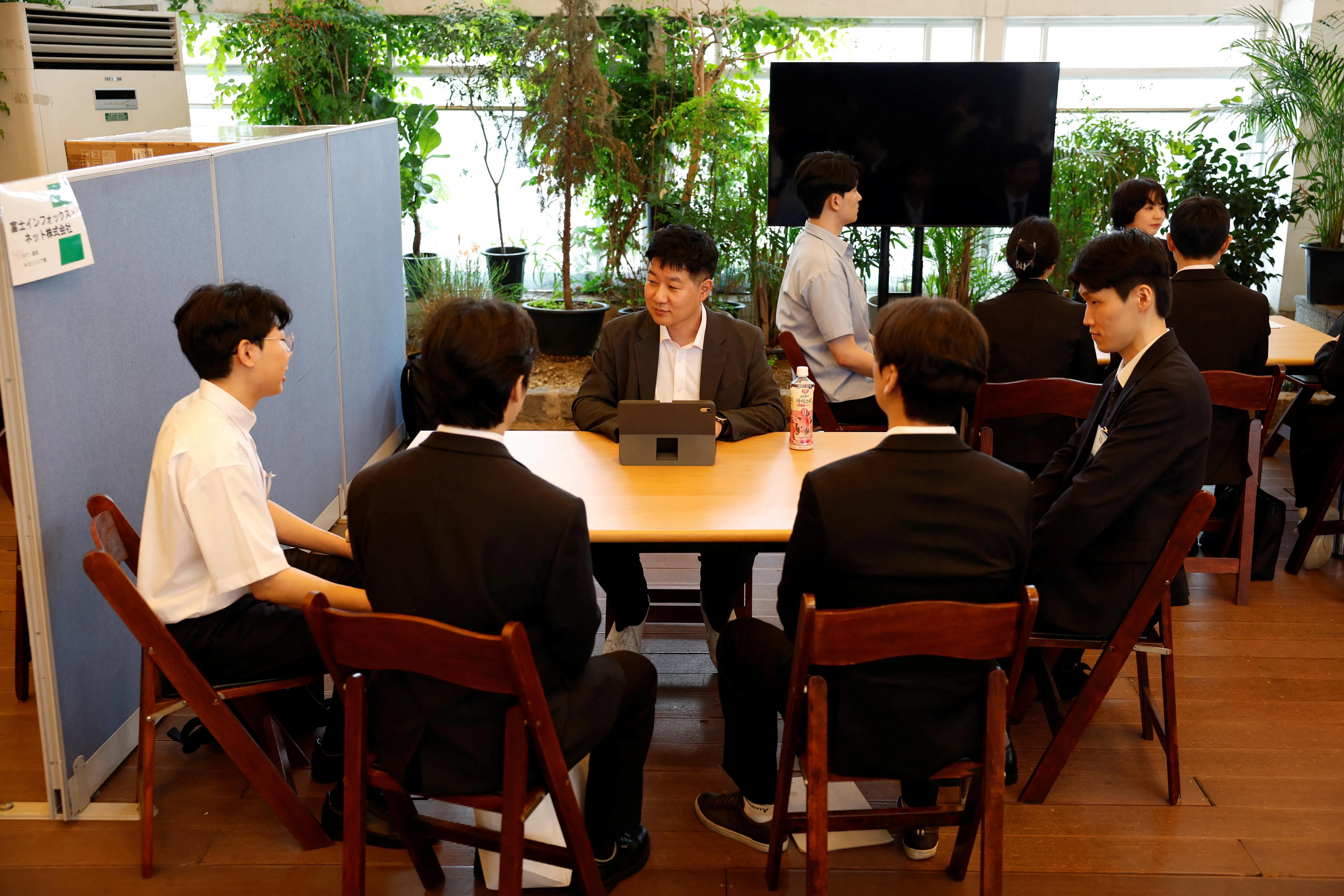 7月12日，韩国求职者在首尔举行的招聘会上，参加了与一家日本公司代表进行的小组面试。（路透社）
