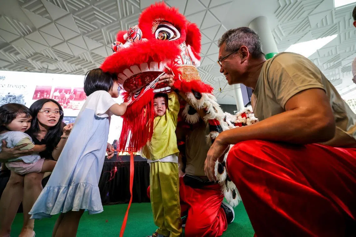 养正小学校友会舞狮俱乐部的校友在新加坡文Fun节嘉年华从旁指导，让孩童们体验舞狮乐趣。（叶振忠摄）