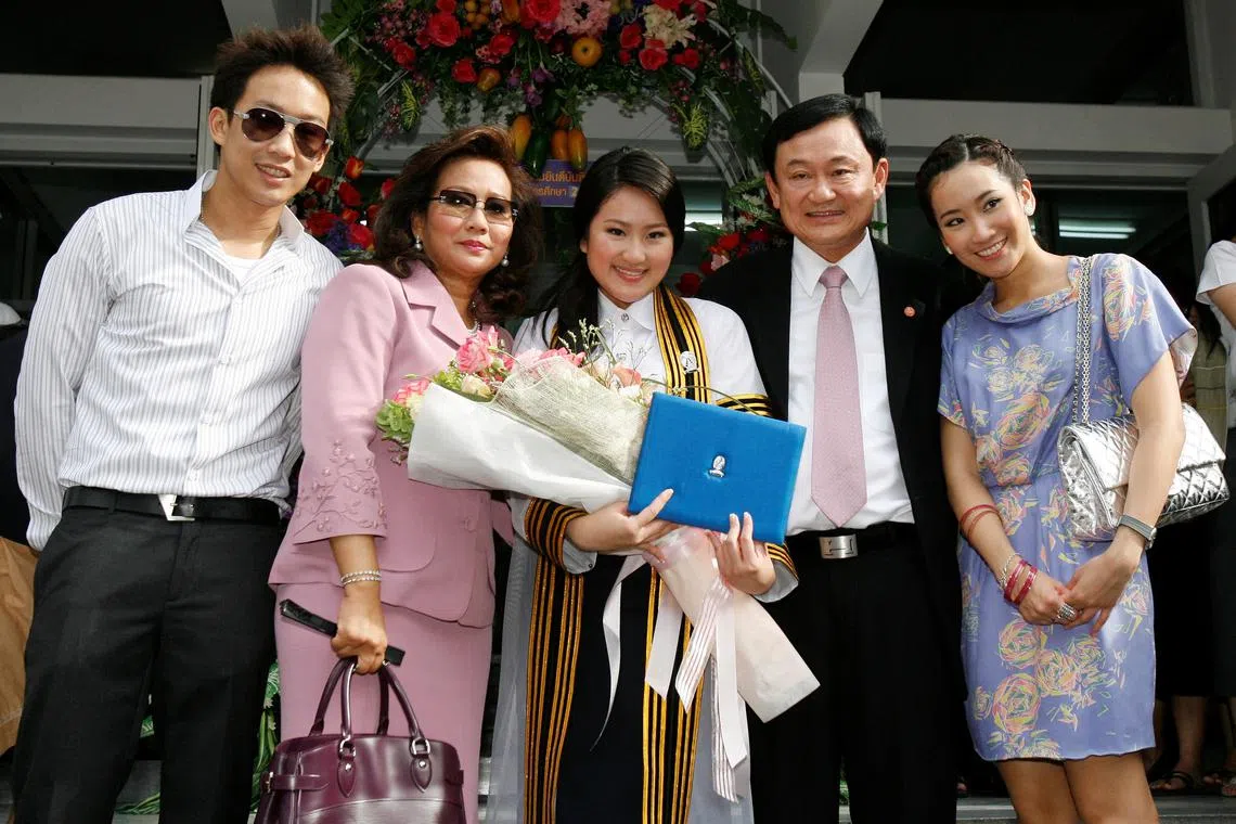 2008年7月，泰国前首相达信（右二）流亡海外前，在曼谷出席幼女佩通坦（中）的大学毕业典礼。（路透社）