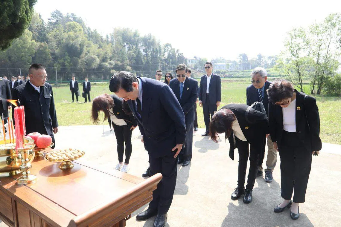 马英九（前）与四名姐姐在祖父的坟墓前上香后鞠躬。（马英九办公室）