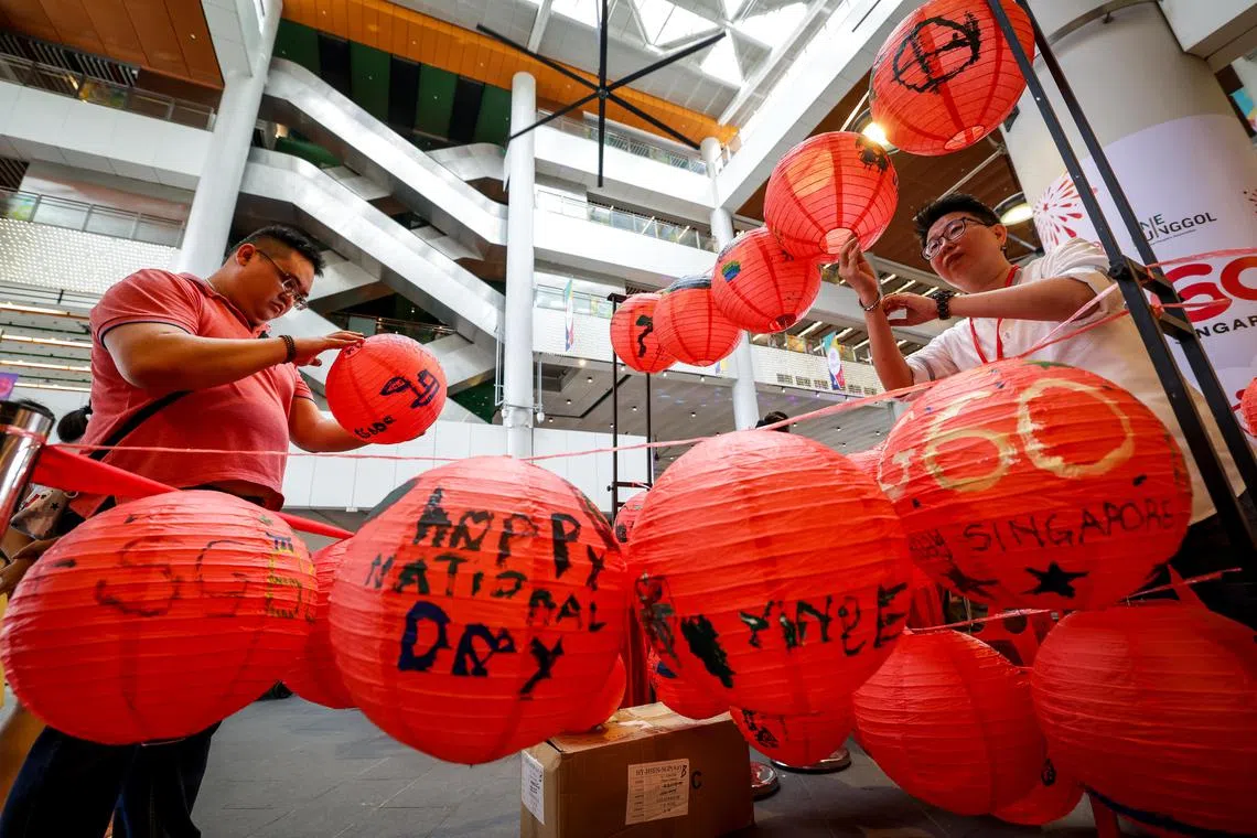 榜鹅居民7月13日共聚榜鹅综合社区中心的种族和谐庆祝活动上，将他们对新加坡未来的期望和心愿绘写在500盏红色灯笼上。这些对国家的美好祝语，将在下个月东北区国庆邻里庆祝活动上，化作一盏盏象征着居民精诚团结的“小红点”点亮现场。（叶振忠摄）