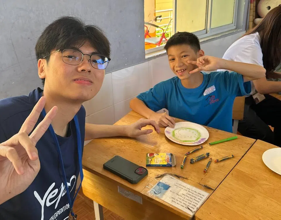 陈昱铭（左）在越南参与国际服务学习活动，与当地学生合照。（受访者提供）