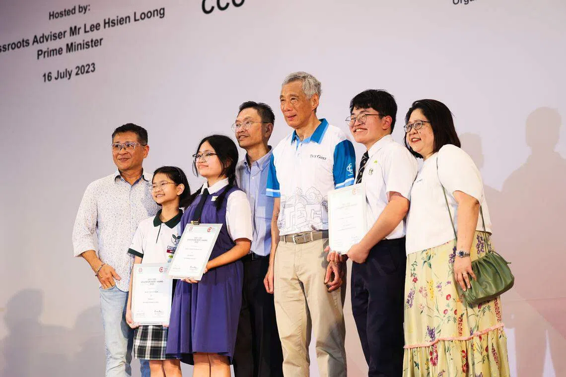 蔡瑞轩 （左二）、蔡瑞恩（左三）和蔡睿祥（右二）三兄妹从李总理（右三）手中接过教育优异奖。他们的父亲蔡金松（左四）、母亲陈碹美（右一）和舅舅陈材福（左一）也出席了颁奖礼。（蔡家增摄）