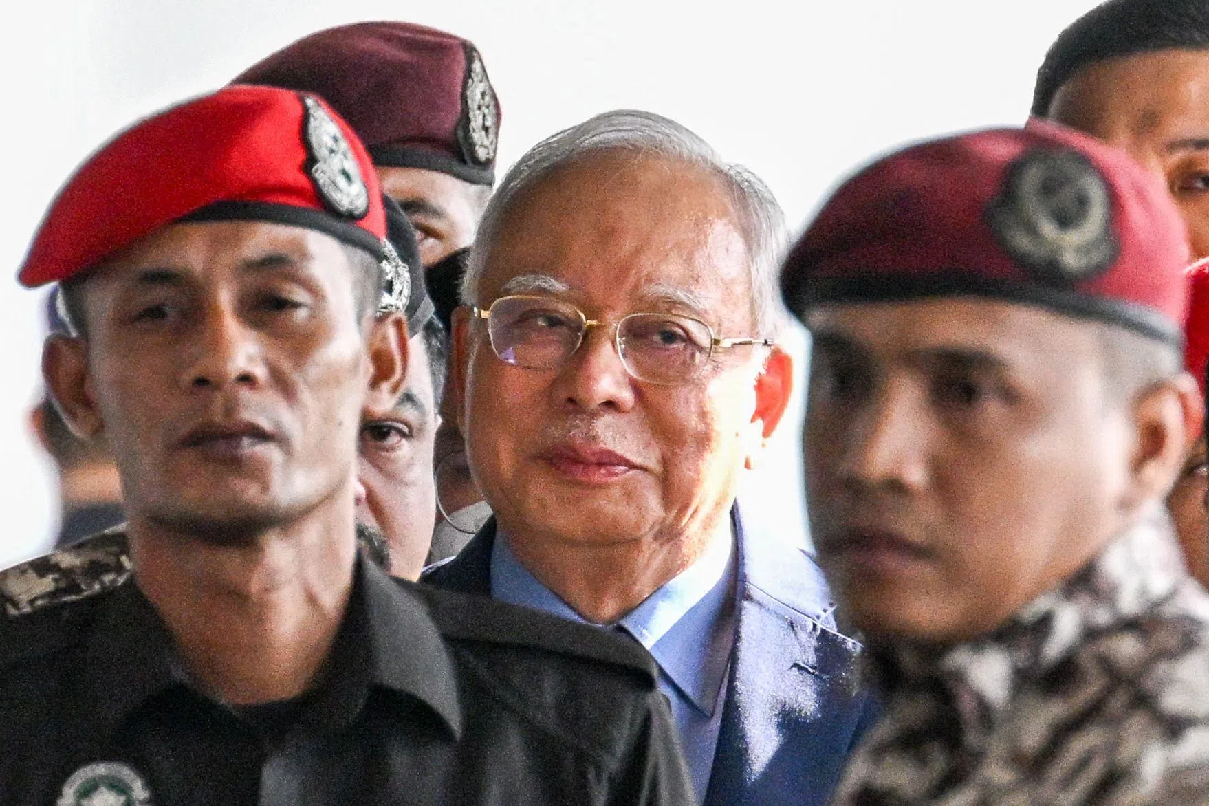 马来西亚前首相纳吉（中）获得国家元首有条件特赦，以居家服刑的方式服完SRC国际公司案的剩余刑期。图为纳吉2024年10月针对另一起一马案出庭。（法新社）