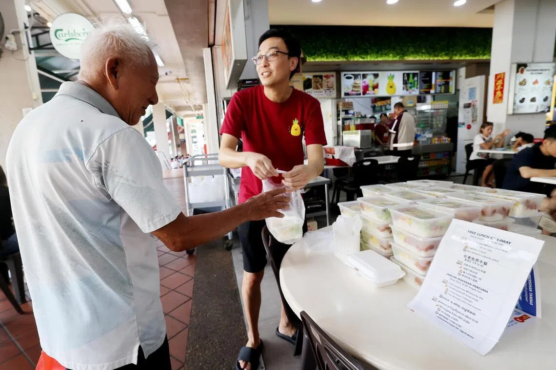 郭先生（左）已数次前来领取 免费餐，并感谢店主善举。（庄耿闻摄）