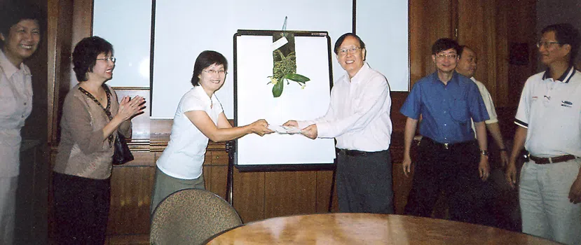 丘才新（右四）70大寿时，学生李风英（左三）代表同学赠送以他名字命名的胡姬花“Phalaenopsis Hew Choy Sin”，作为生日贺礼。（受访者提供）