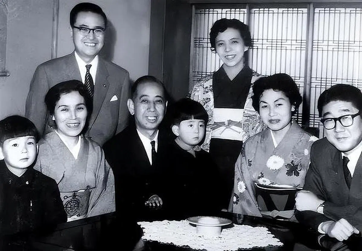 儿时的安倍晋三（中）与外公岸信介（前排左三）、父亲安倍晋太郎（前排右一）、母亲洋子（后排右）等长辈合照。（互联网）
