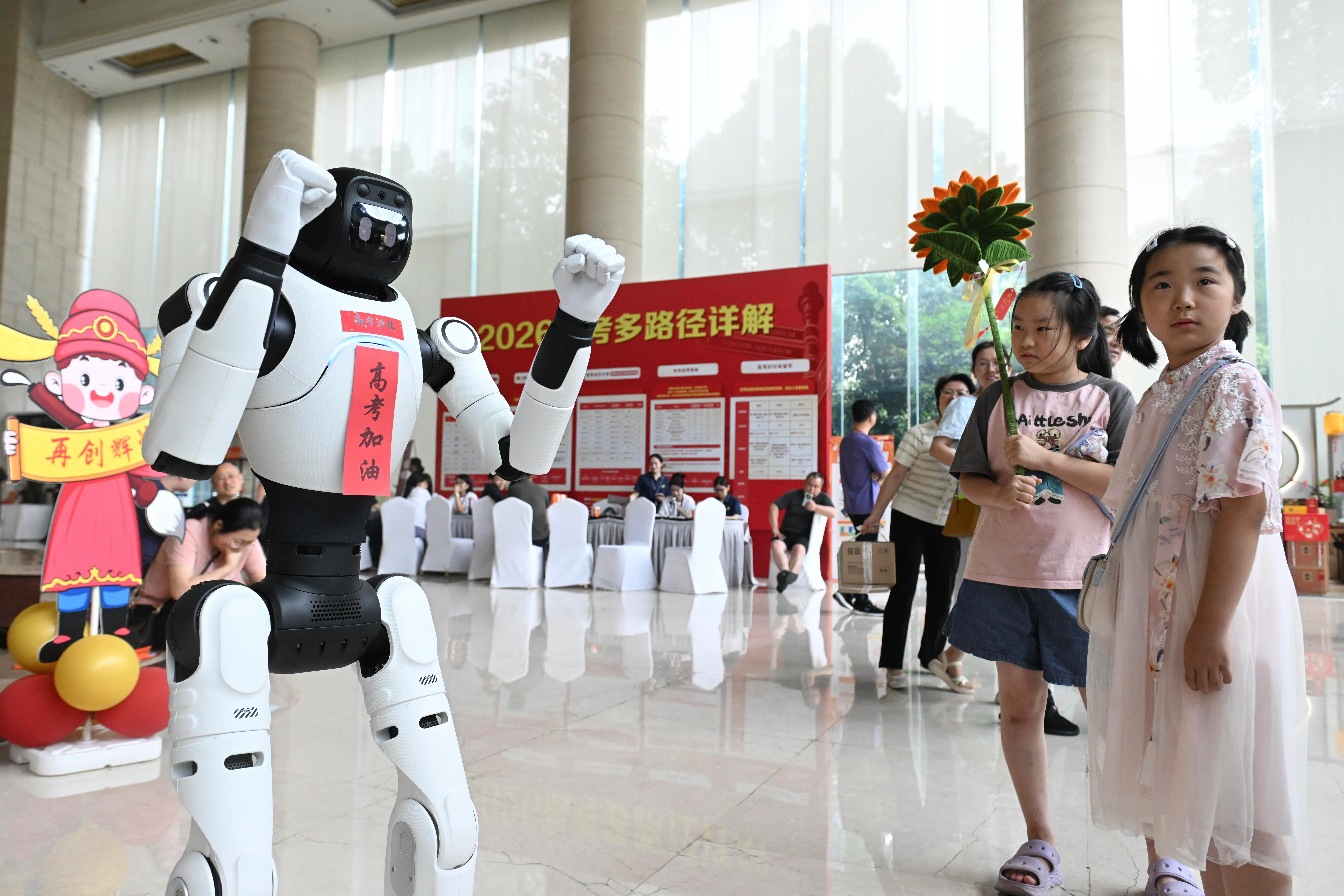 中国全国高考星期天（6月7日）拉开帷幕。在安徽省合肥市一考点外的休息区，机器人化身祝福使者，为考生、家长加油鼓劲。（中新社）