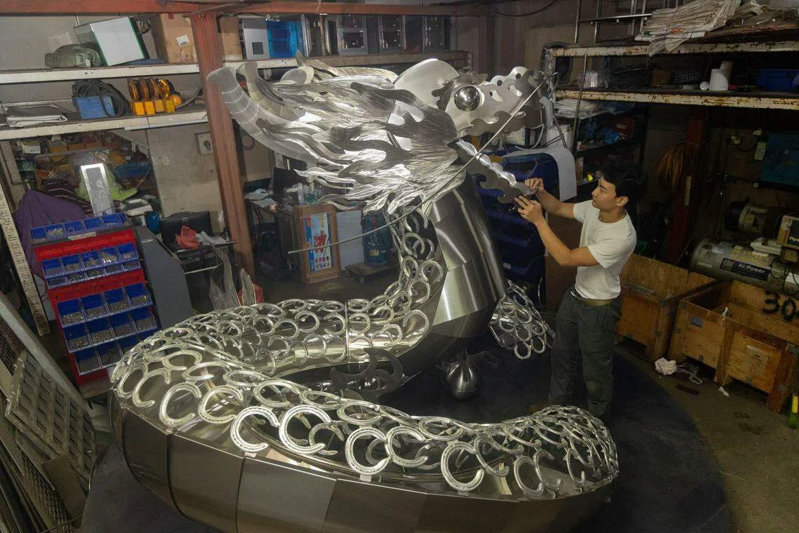 金属设计工作室Baremetalco创办人杨展昂利用338个马蹄铁创作出一条威风凛凛的“铁甲龙”。（吴先邦摄）