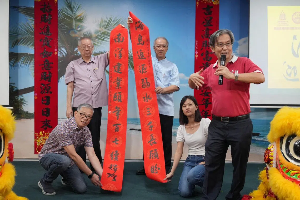 南洋书法中心创办人王运开（右）赠送对联给海南会馆。（谢智扬摄）