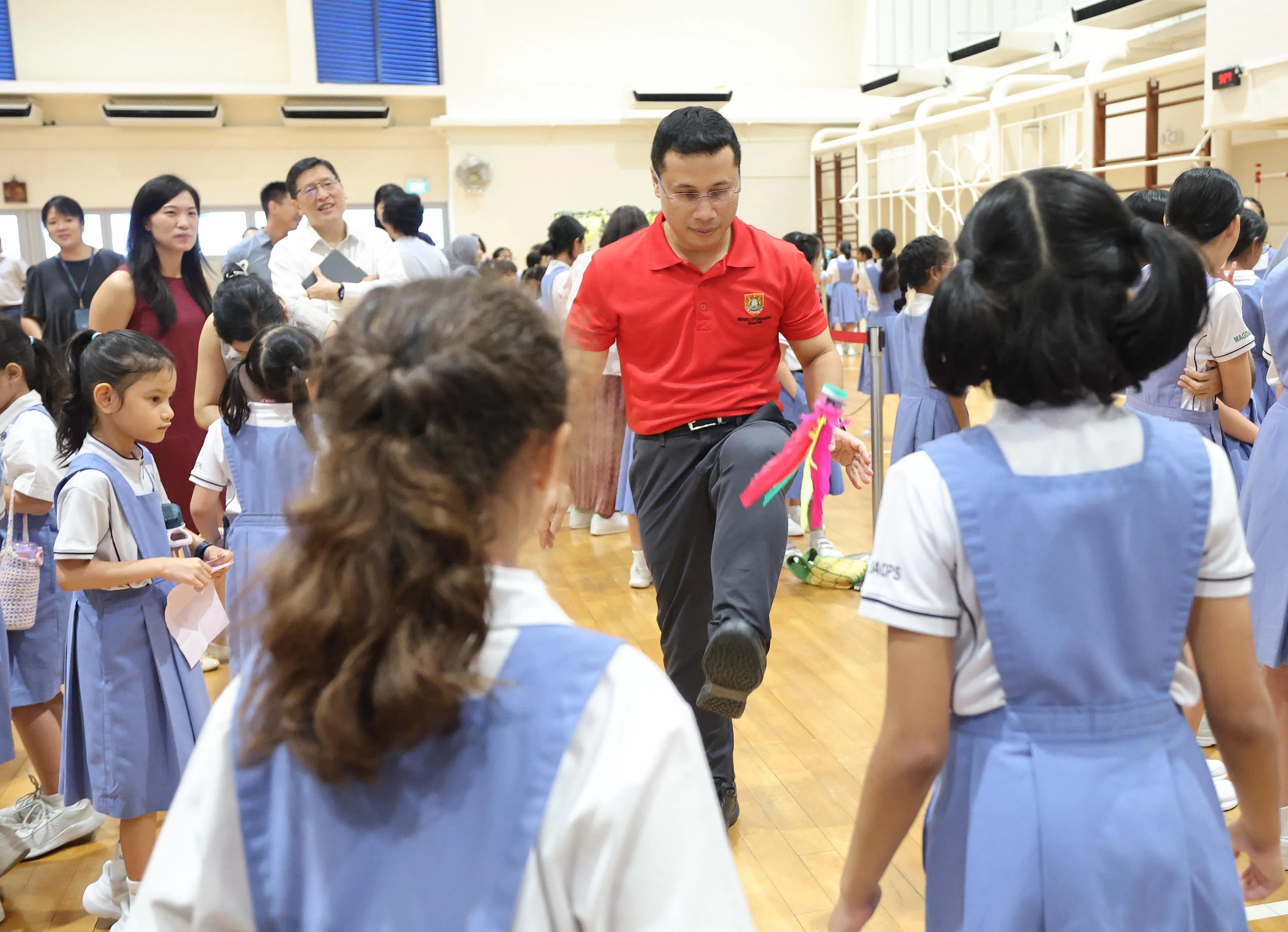 李智陞和学生一起玩传统游戏如踢毽子。（唐家鸿摄）