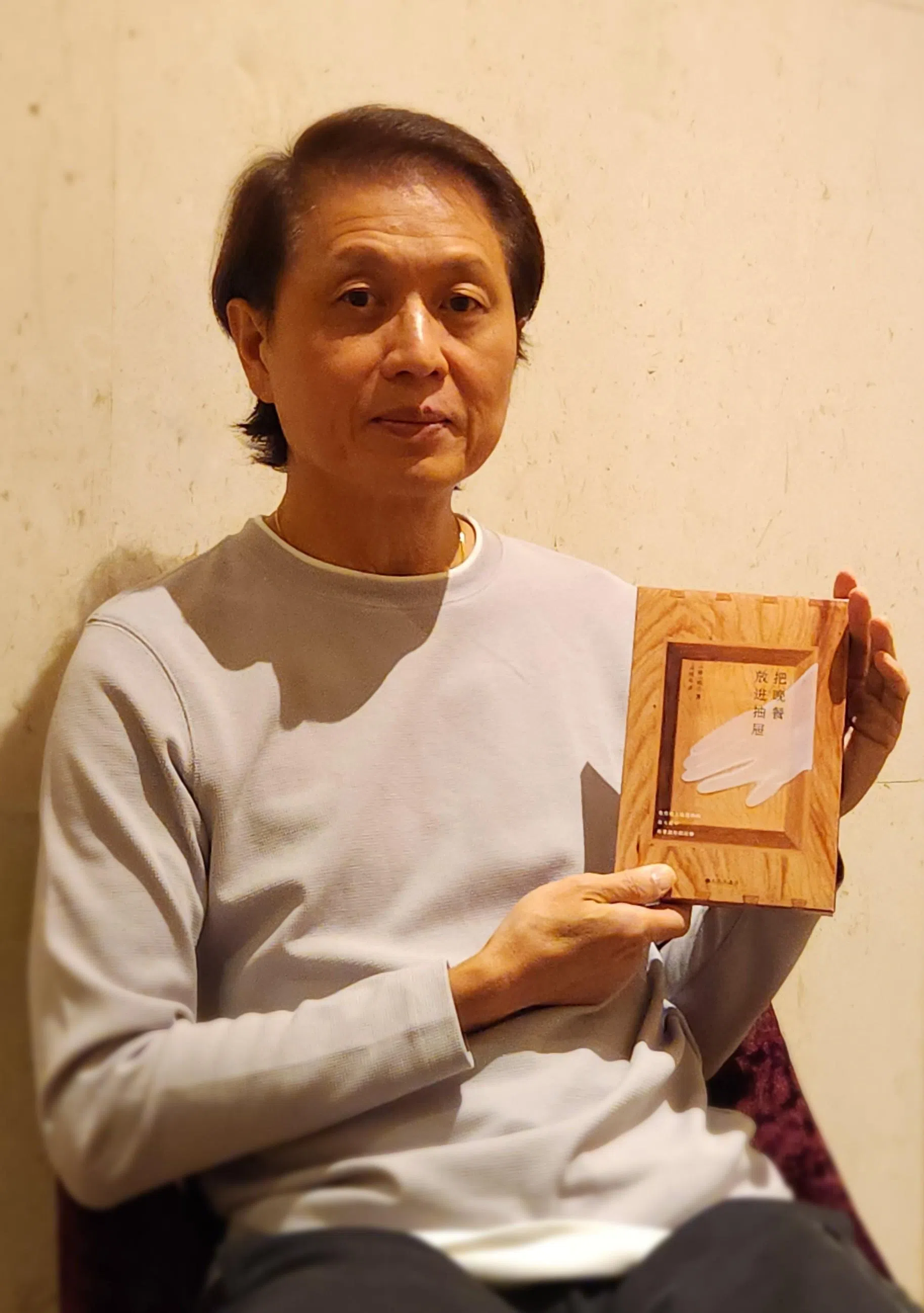 吴耀宗赏读韩江唯一诗集《把晚餐放进抽屉》。（吴飞响摄）