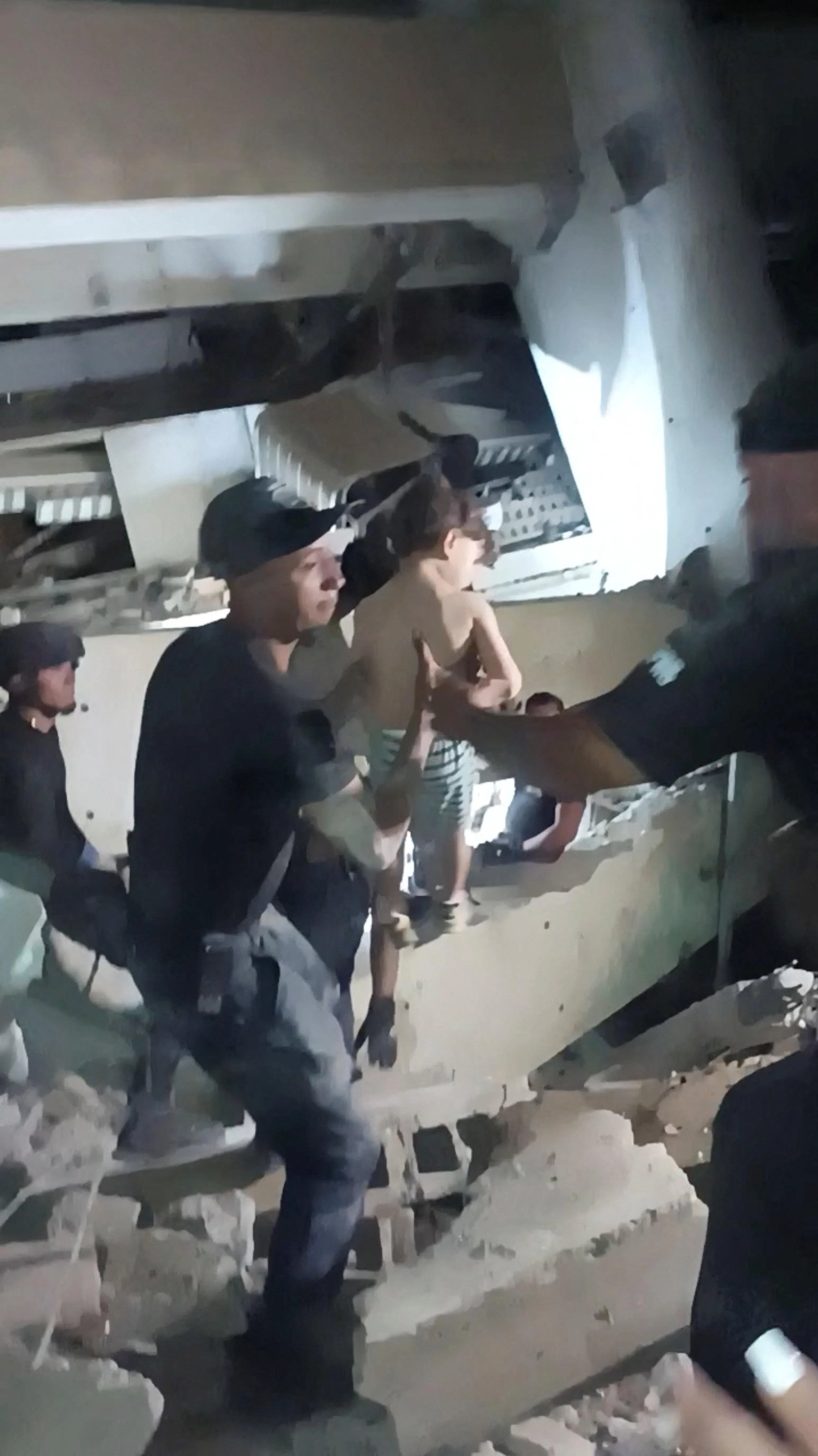 搜救人员在拉瓜伊拉一栋倒塌建筑物底下救出一个儿童。（视频截图／路透社）