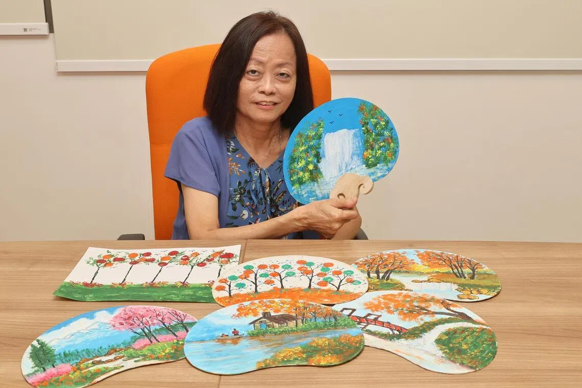 谢玉鸾教病患填色时，会先在画纸上描绘出图案，再让他们上色。（唐家鸿摄）