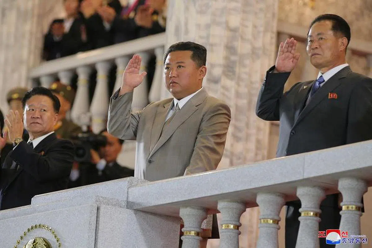 朝鲜最高领导人金正恩在阅兵检阅台上向正在步操的军人致意。（朝中社） 