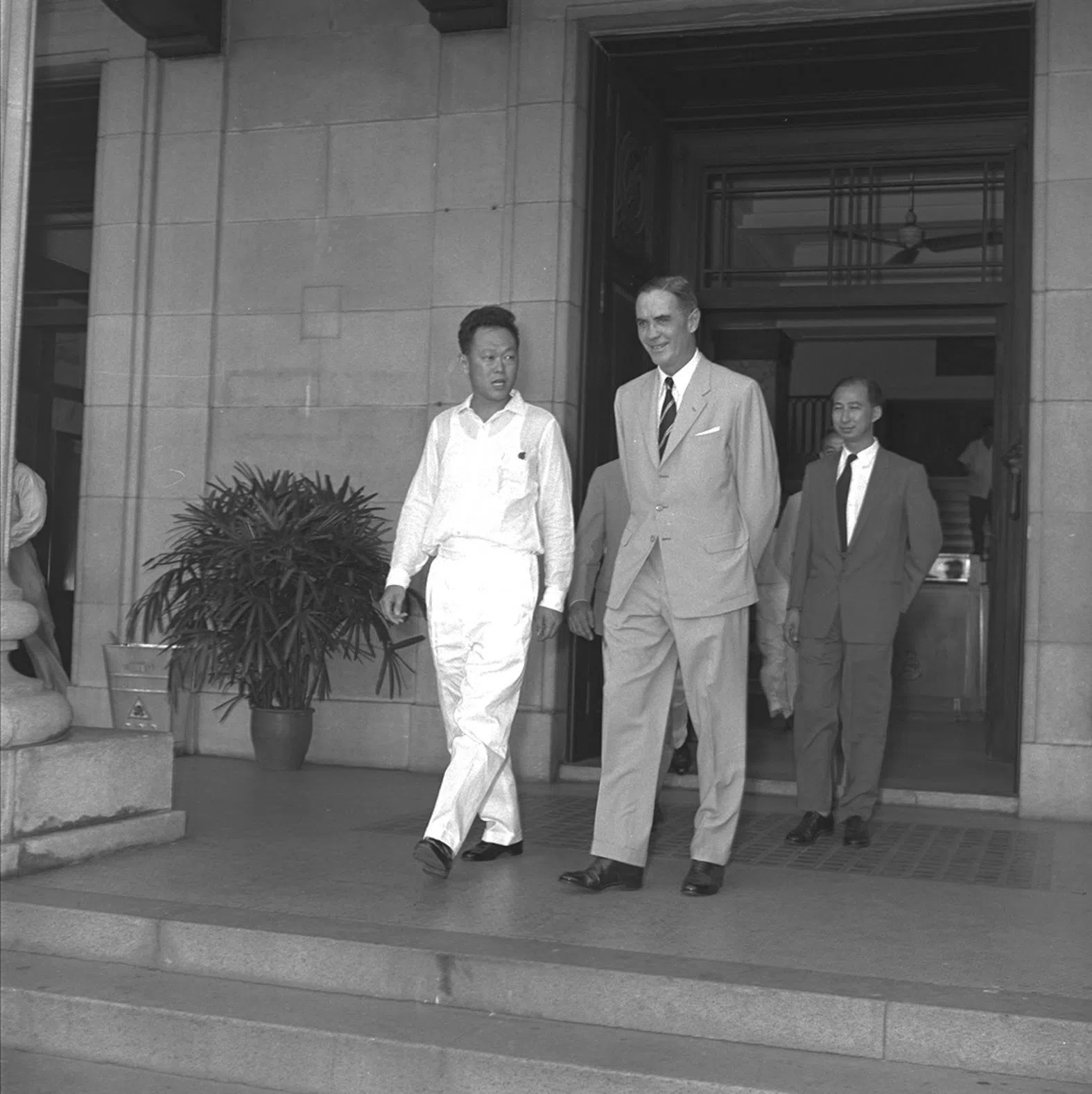 1959年6月5日，新加坡自治邦第一任总理李光耀（左）和首任元首顾德在内阁宣誓就职仪式结束后，步出市政厅。（档案照片）