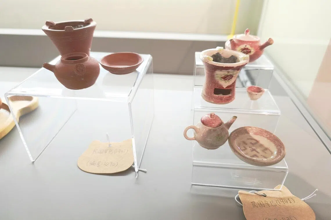 展柜中陈列着茶壶、炉子、碗碟与杯子等小陶器，其中一些炉子甚至装有木炭，仿佛保留着墓主当年生活的痕迹。（郑一鸣摄）