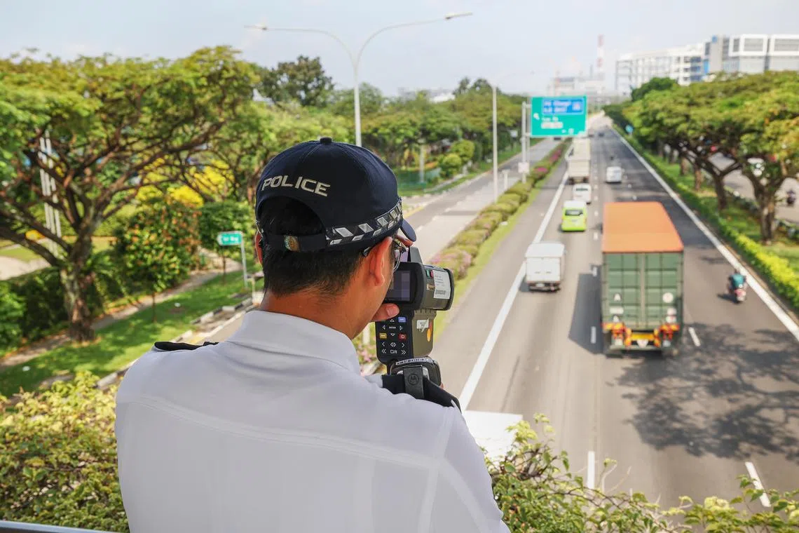 交警在亚逸拉惹快速公路天桥上，使用激光测速摄像机对重型车辆测速。（蔡家增摄）