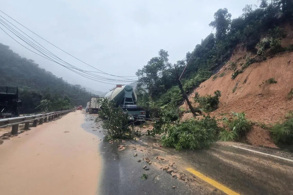 11月17日，暴雨引发越南庆和省庆黎山口附近发生山体滑坡，导致多辆汽车被困在损毁的道路上。（法新社）