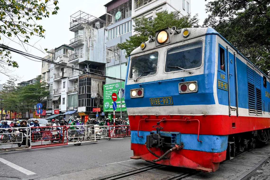 2月18日，一辆火车在越南河内的铁路道口等待通过。（法新社）